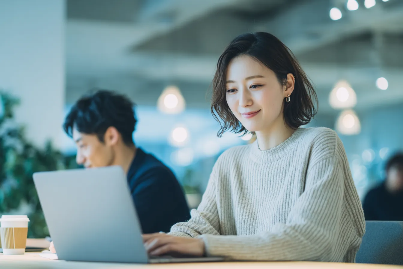カフェのような場所でノートパソコンを開く人